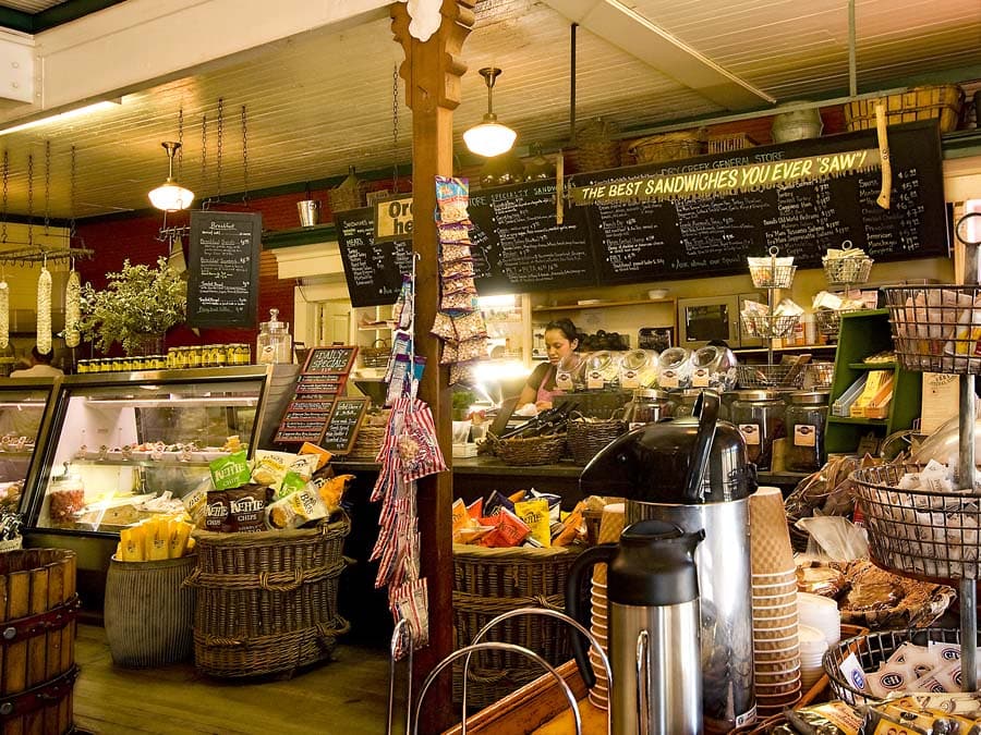 A person makes a sandwich behind the counter