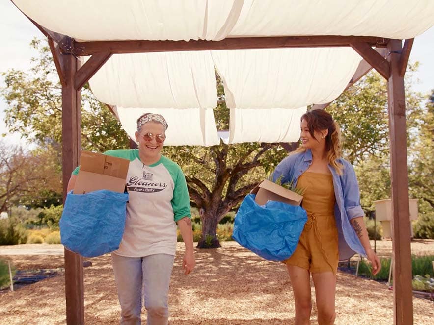 People carrying bags of fresh produce