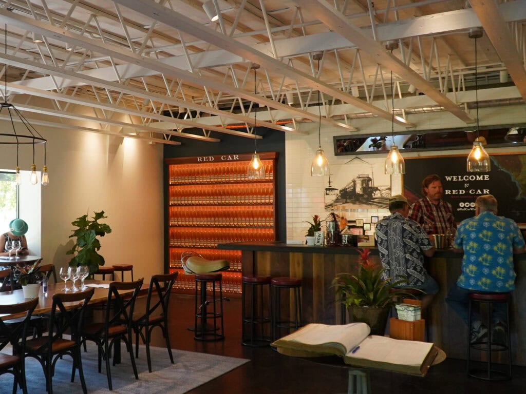 people enjoying a wine tasting inside red car wine co