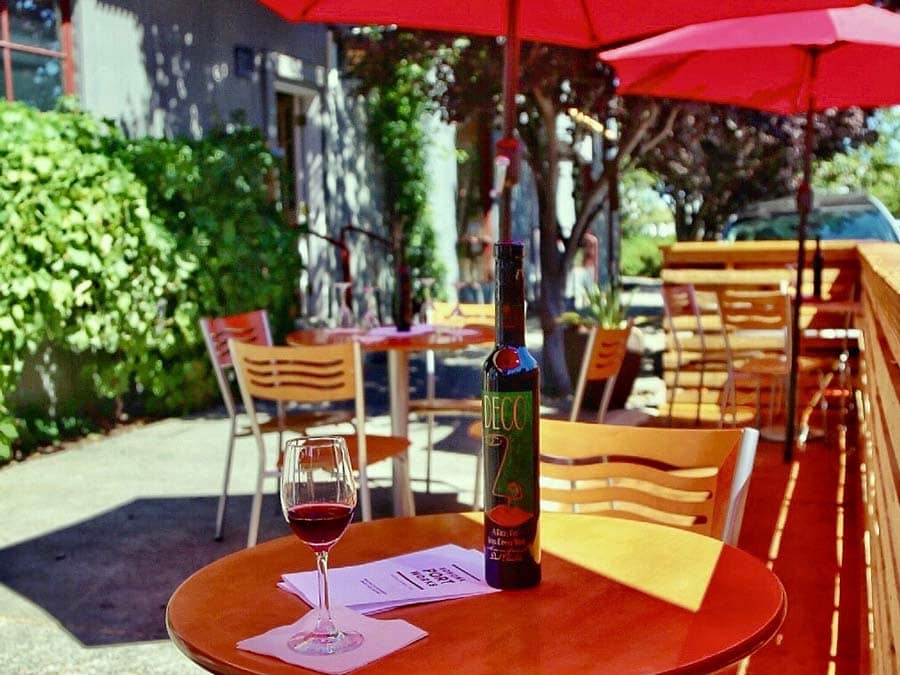 A table with an umbrella that has a glass of port waiting to be tasted