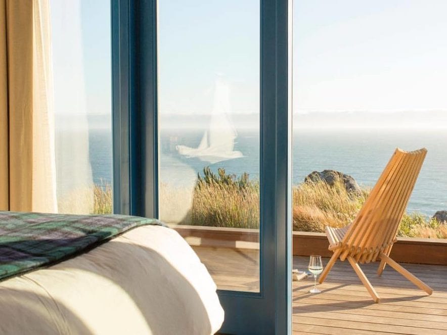 Ocean and balcony view from inside a guest room at Timber Cove Resort