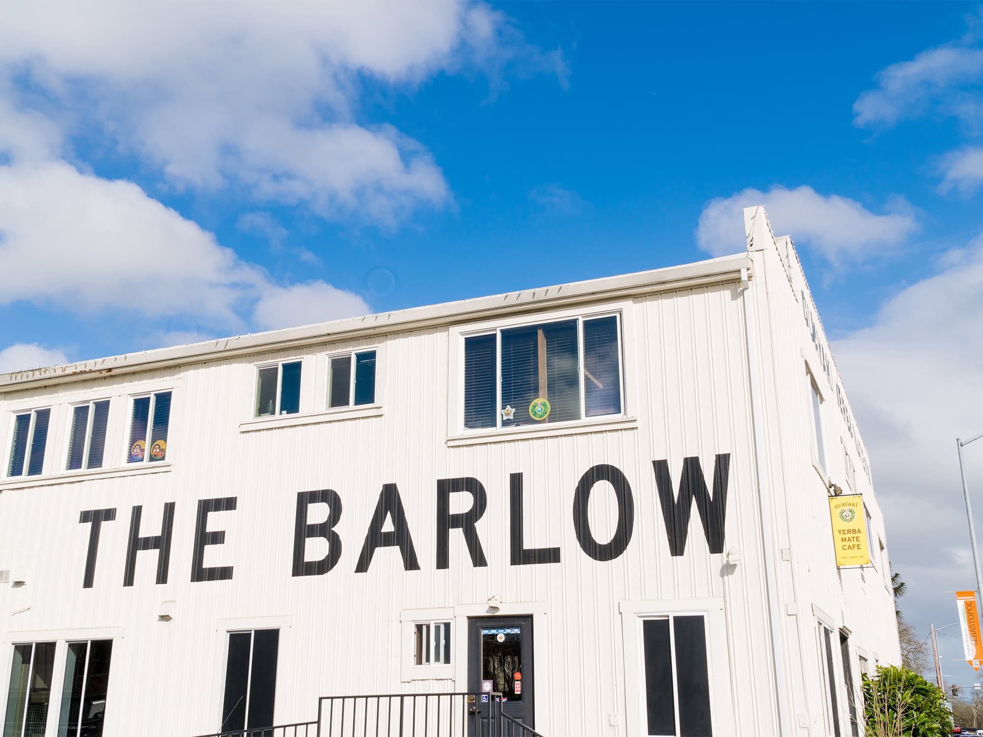 A white buildong has the words The Barlow in big, black letters on it