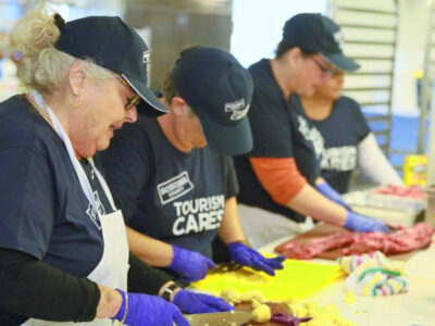 Marjorie Sands, left, chops veggies with other Tourism Cares volunteers at Sonoma Family Meal.