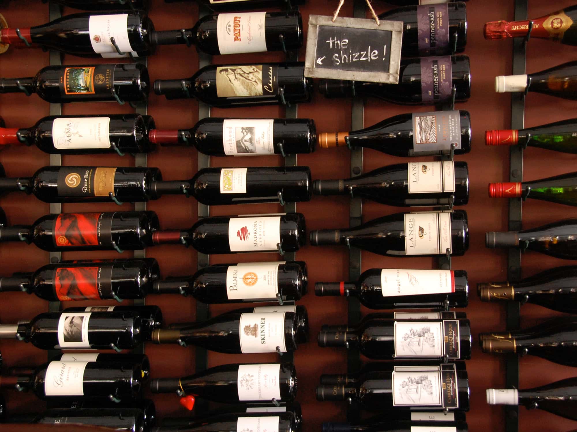 Bottles of wine displayed horizontally on the shop's wall