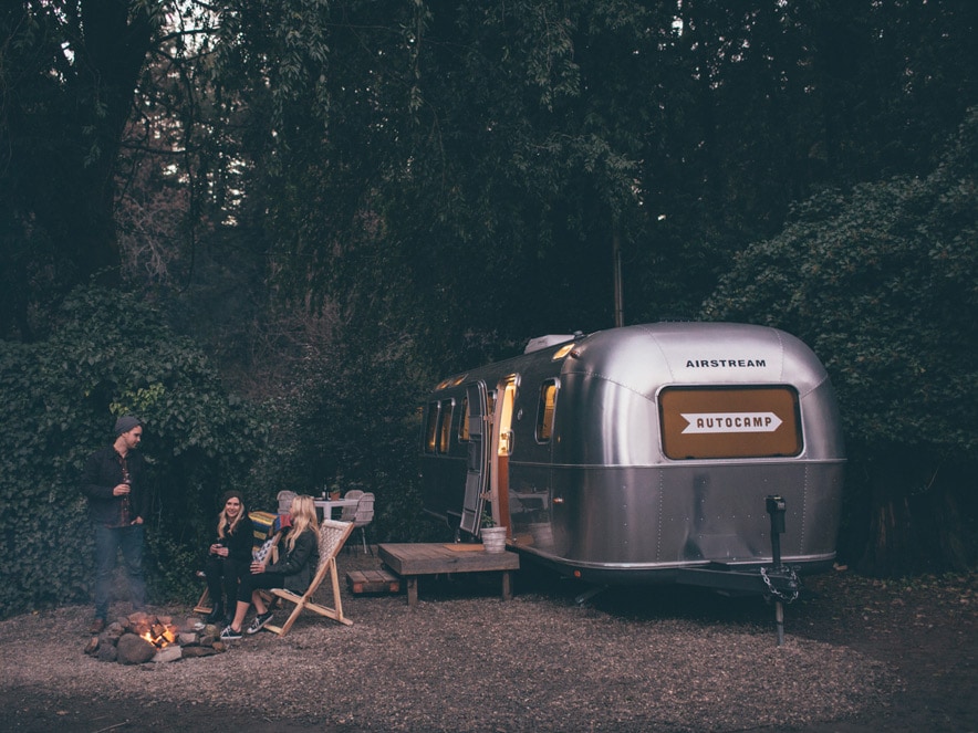 People sit outside of a silver Airstream trailer in Sonoma County