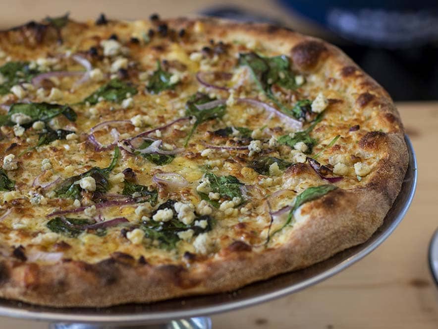 pizza with red onions and spinach