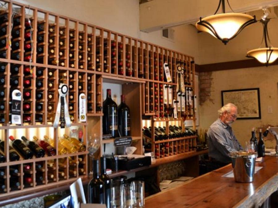 A wall of bottles of wine behind the tasting counter