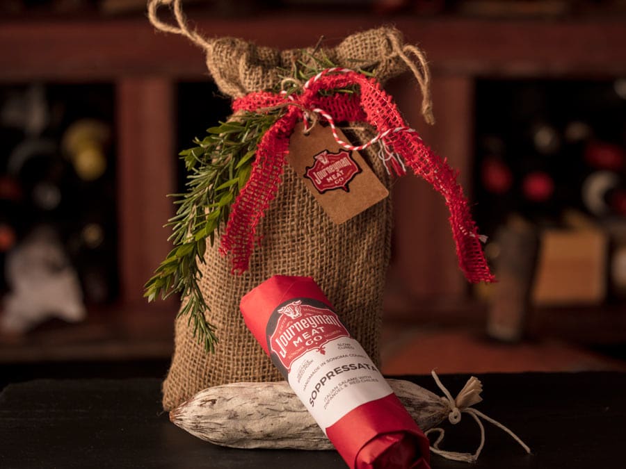 Salami wrapped in a burlap bag decorated with rosemary