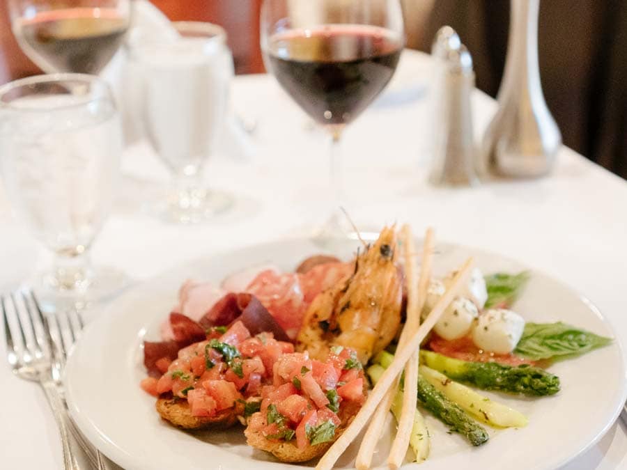 Shrimp served on top of pasta served with wine 