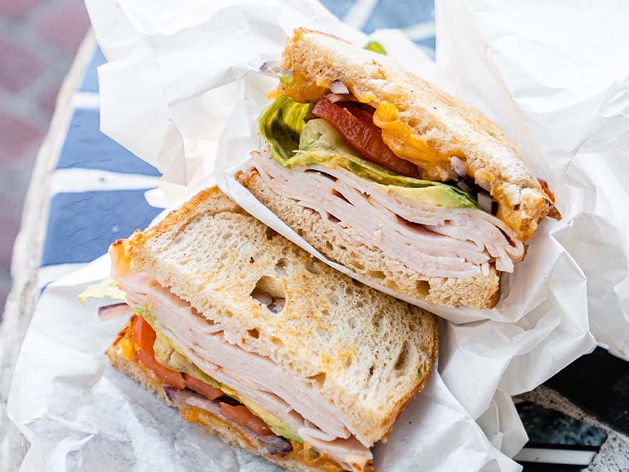 turkey sandwich in paper wrapping on table