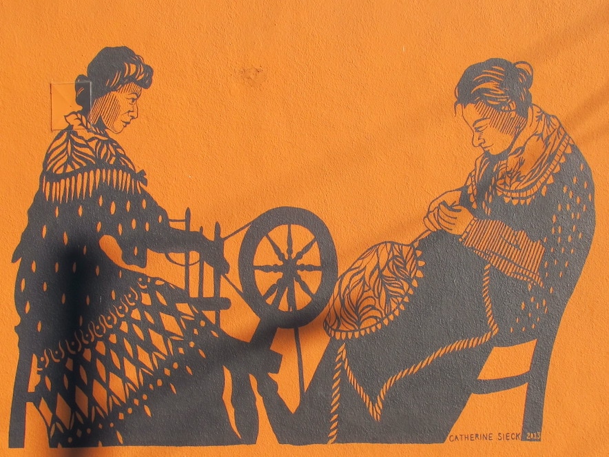 Orange and black mural of two spinster sisters outside Spinster Sisters restaurant in Santa Rosa 