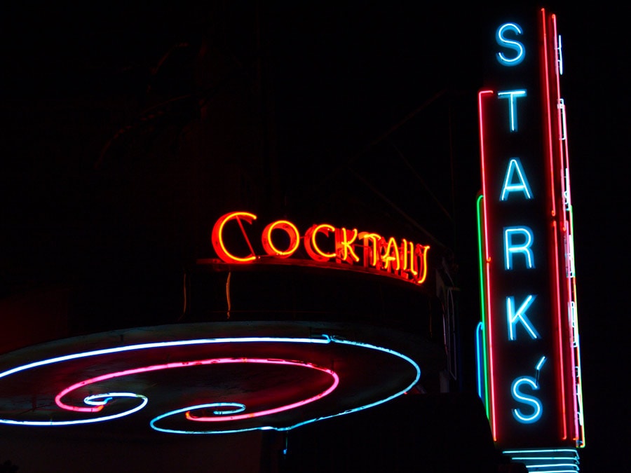 The neon marquee for the restaurant glows in pink and blue at night