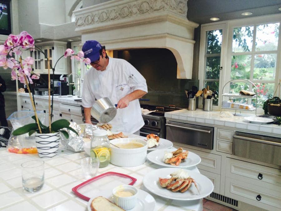 A person cooks in a white-colored kitchen