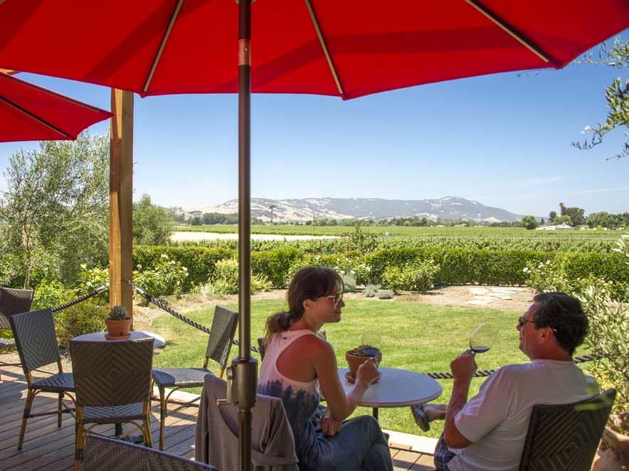 People sit on a patio overlooking the vineyards in Sonoma County