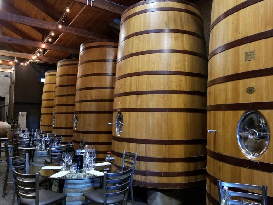 Tabes set up for tasting in the barrel room with big, wooden wine tanks at Dry Creek Vineyard, Healdsburg