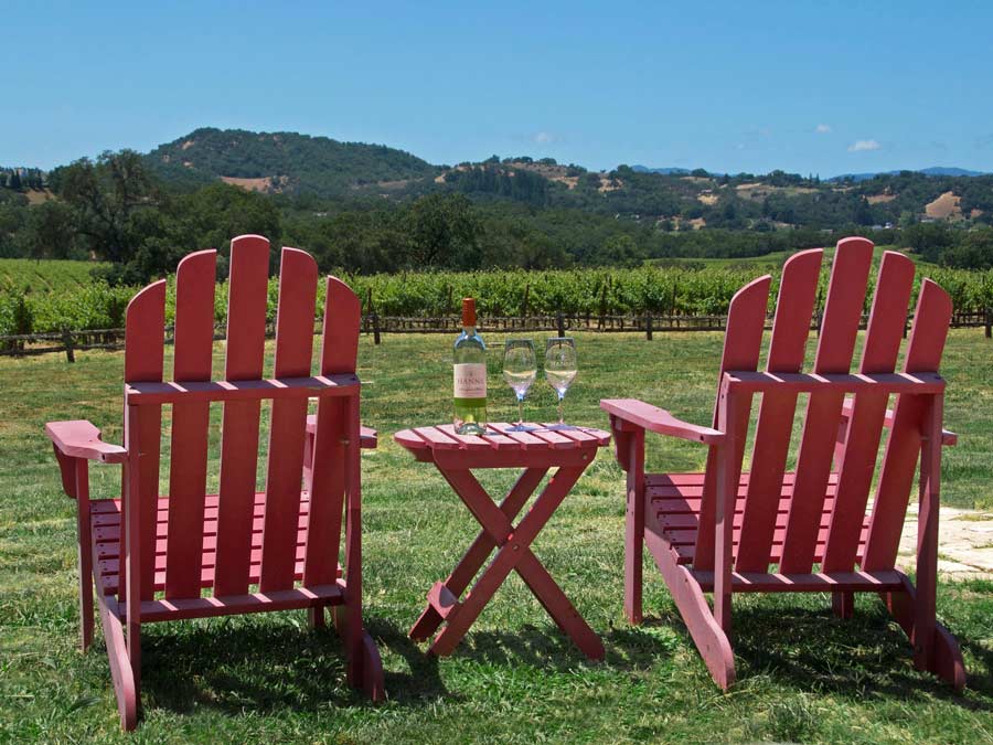 Two red adirondack chairs overlook the vineyard at Hanna Winery - Alexander Valley Hospitality Center, Sonoma County