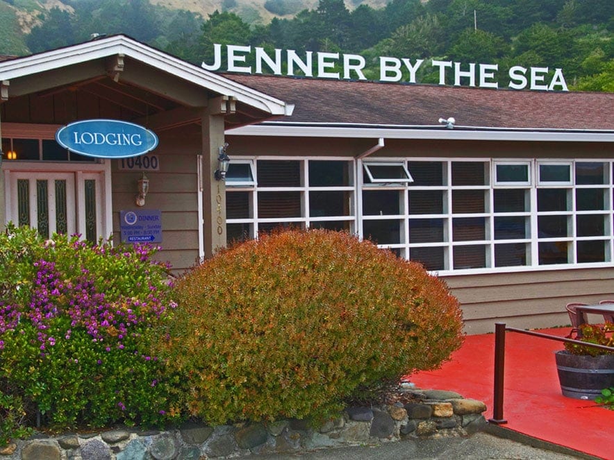 Jenner by the Sea sign hangs over a red overhang at the hotel in Sonoma County