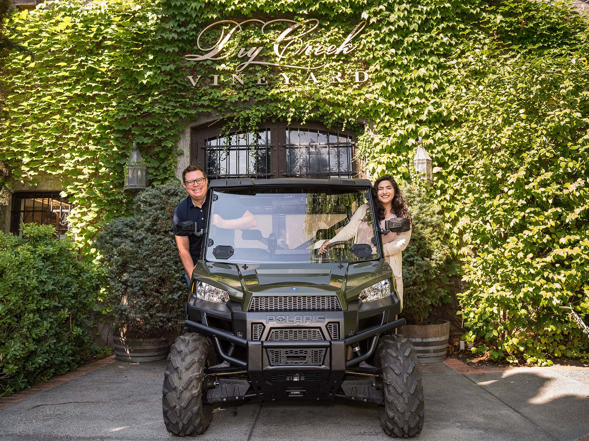 2 people in a off road vehicle outside a tasting room