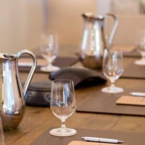 Water pitchers and glasses sitting on conference table